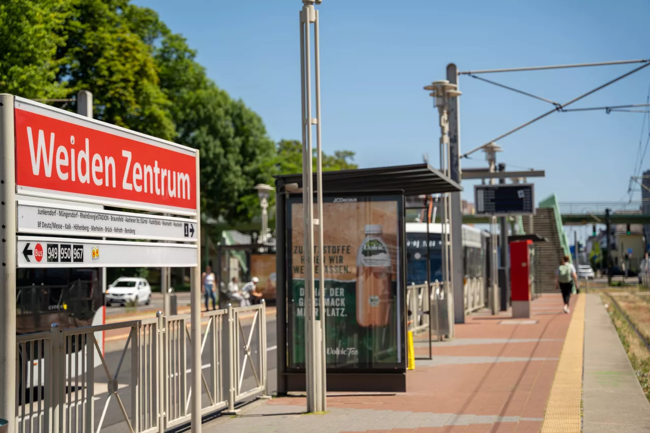 Haltestelle Weiden Zentrum Seitlicher Blick vom Bahnsteig auf das Haltestellenschild Weiden Zentrum mit Blick auf die Fußgängerbrücke